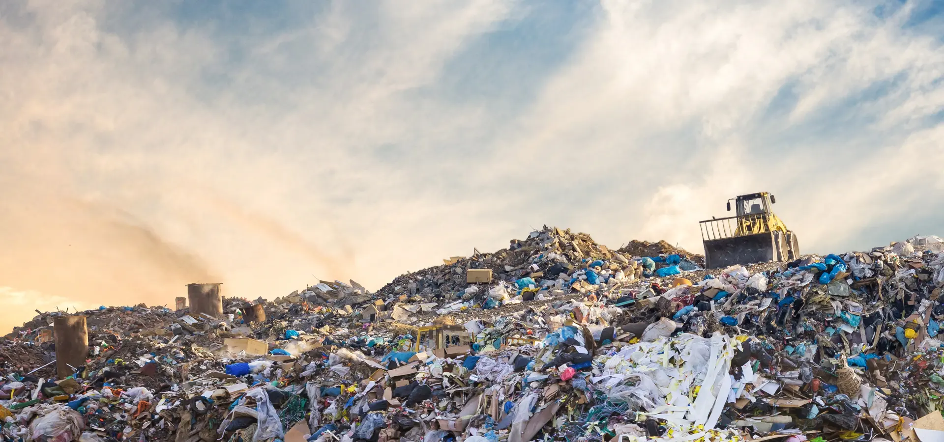 Bulldozer at a landfill site full of plastic
