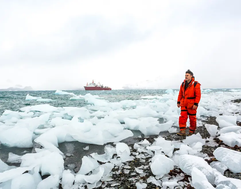 Man walking along icy beach