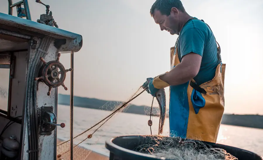 A man working with fishing nets at sea