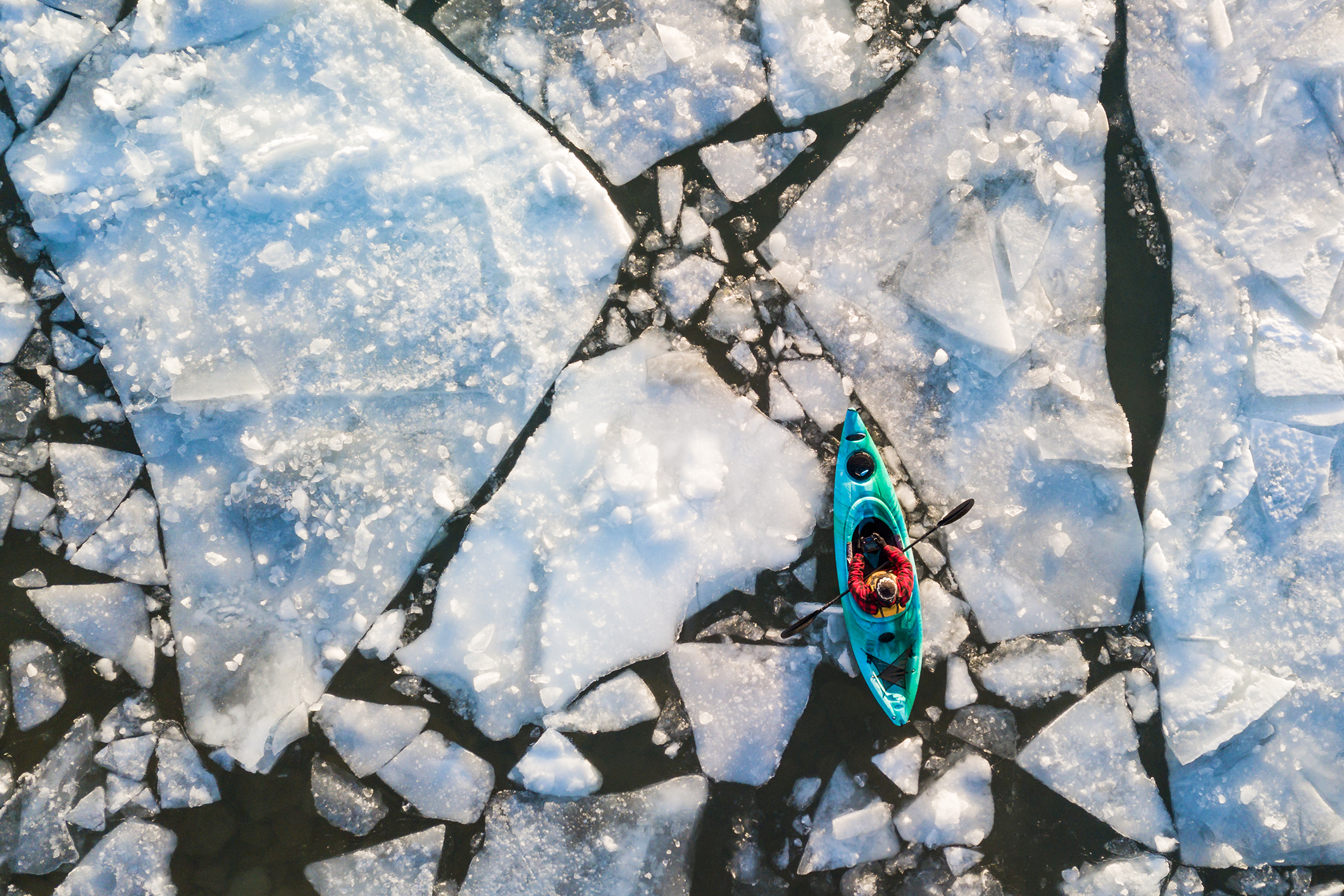 Man kayaking through ice