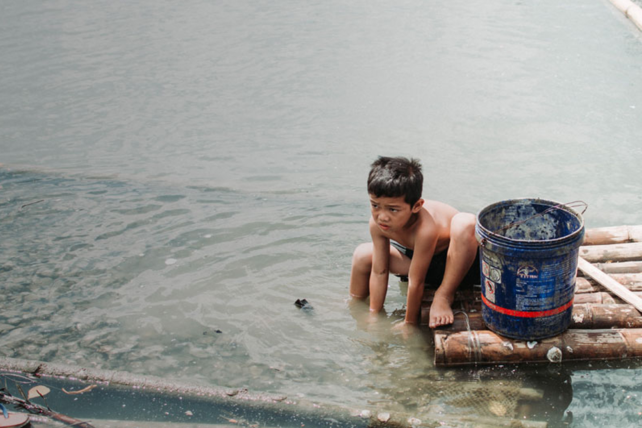 Boy washing in polluted water