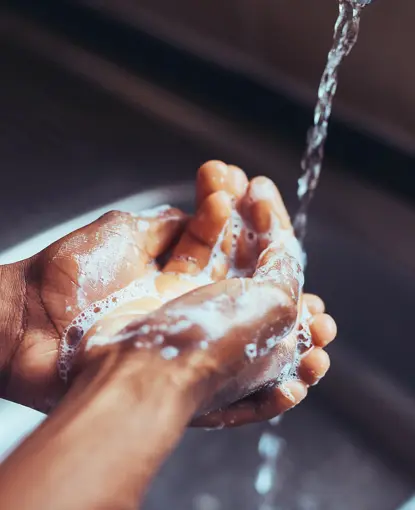 Soapy hands under tap
